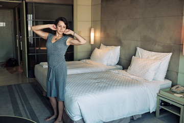 Obraz premium Woman stretches from tiredness, it's time to go to sleep.