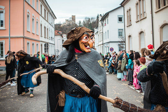Schlosshexe aus Buchholz - Lustige Hexe mit gro&szlig;en Augen und langer Nase vor sch&ouml;ner Stadtkulisse und einer Burg im Hintergund. Bei Fastnachtumzug in Waldkirch S&uuml;d Deutschland.