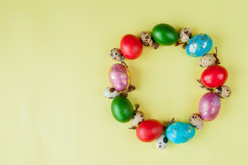 Top view painted eggs Easter Frame in circle shape on a yellow background. Copy space