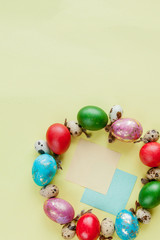 Top view painted eggs Easter Frame in circle shape on a yellow background. Copy space