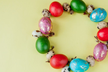 Top view painted eggs Easter Frame in circle shape on a yellow background. Copy space