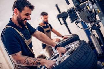 Handsome young man changing tires