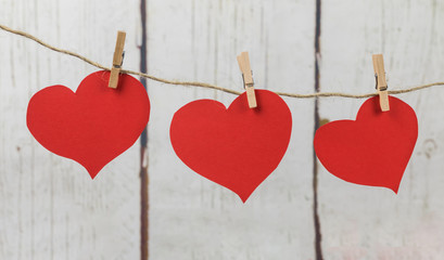 Red cardboard hearts hanging with wooden clothespins