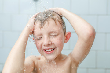 little boy washe in the shower shampoo on his face