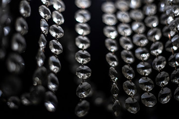 Glass elements transmit light from lamps. A chandelier spreads light through repeating wands. Cold background. Abstract background.