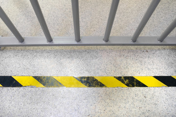Grey cells in the bank with the yellow do not cross tape on the floor.