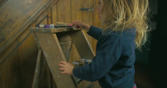 Preschooler standing on stepladder doing some painting