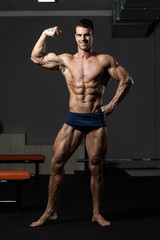 Fototapeta na wymiar Bodybuilder Fitness Model Posing Biceps After Exercises