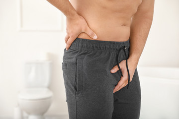 Young man with urologic disease in bathroom