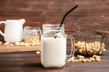 Mason jar of cashew milk on wooden table