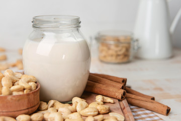 Jar of cashew milk with nuts on wooden table