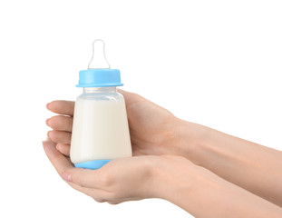 Female hands with bottle of milk for baby on white background