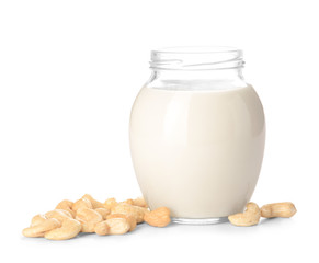 Jar of cashew milk with nuts on white background