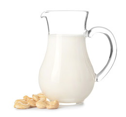 Jug of fresh cashew milk on white background