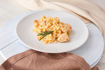 Plate with tasty rice and chicken on table