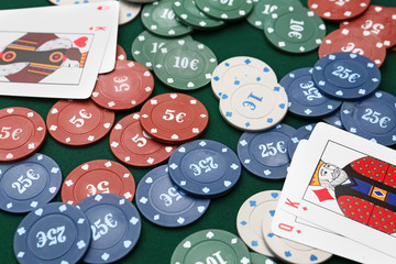 Chips and playing cards for gambling games on table in casino