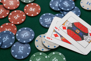 Chips and playing cards for gambling games on table in casino