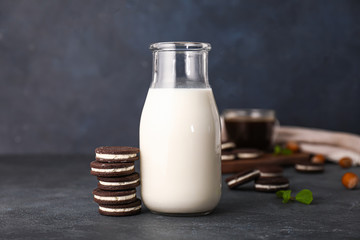 Tasty chocolate cookies with milk on dark background