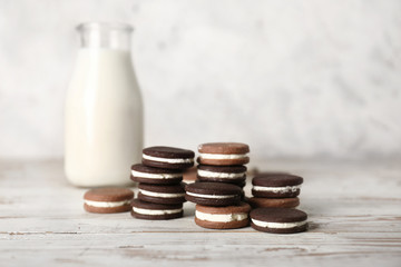 Tasty chocolate cookies with milk on white table