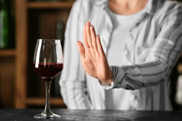Woman refusing to drink wine in bar. Concept of alcoholism