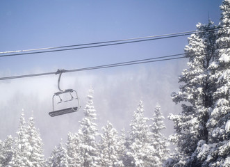 Chair lift above snowy trees at ski resort