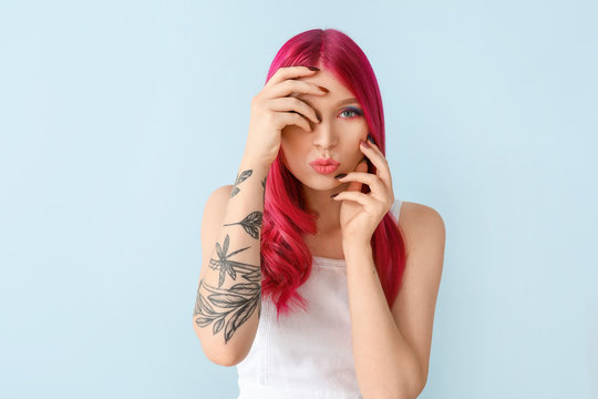 Beautiful young woman with unusual hair on color background