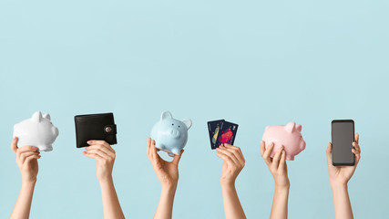 Female hands with piggy banks, credit cards, wallet and mobile phone on color background. Concept of online banking - obrazy, fototapety, plakaty