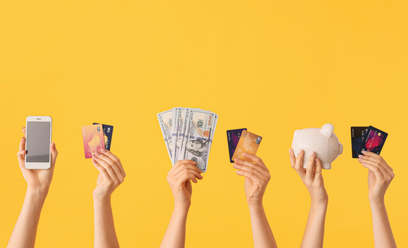 Female hands with money, credit cards, piggy bank and mobile phone on color background. Concept of online banking