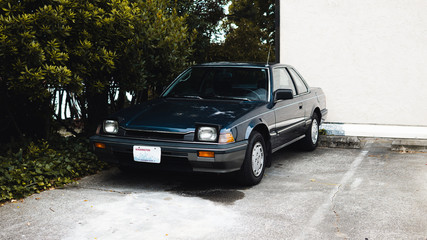 vintage 1990s japanese sports car by trees