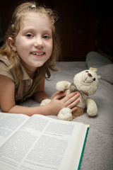 Fototapeta na wymiar Beautiful little girl read book wit favorite toy