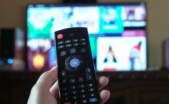 Female hand holding a smart tv remote control