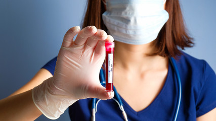 Nurse holding test tube with positive Coronavirus test blood sample. Novel Coronavirus Pneumonia,...