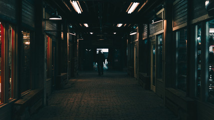 Obraz premium person walking down dark hallway