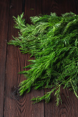 Dill sheaf on a dark wooden rustic board, close up