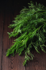 Dill sheaf on a dark wooden rustic board, close up