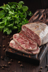 Traditional pork brawn with parsley and pepper on dark wooden board