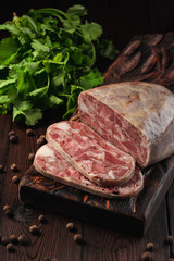 Traditional pork brawn with parsley and pepper on dark wooden board