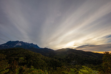 Sunrise at the Mount Kinabalu, Borneo, Sabah, Malaysia. The sun comes up behind the highest mountain in South east Asia, the mount kinabalu. Near the city of Kota Kinabalu. Colorful clouds at the sky