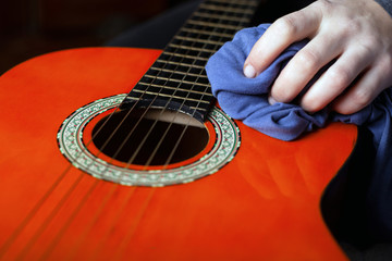 dusting the musical instrument. rub wax acoustic guitar