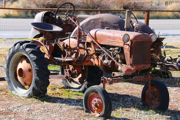 a rusted red old farm tractor