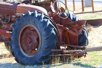 a rusted red farm tractor wheel