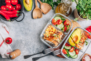 Healthy meal prep containers with chickpeas, chicken, tomatoes, cucumbers and avocados. Healthy lunch in glass containers on light gray background. Zero waste concept. Top view. Flat lay