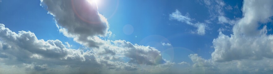 青い空と雲と逆光のパノラマの背景素材