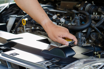 A man examining the water in a car radiator