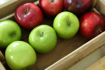 red and green apple fruit in harvest wood basket