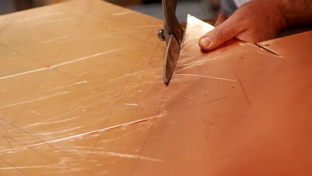 The master with special scissors for metal cuts the shape of the product