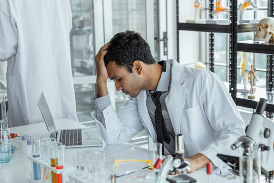 Exhausted stressed research scientists feeling tired worried about problem in chemical laboratory.