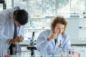 Research scientists in white coats working in modern biological laboratory.