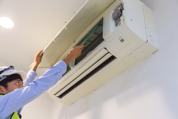 specialist cleans and repairs the wall air conditioner.