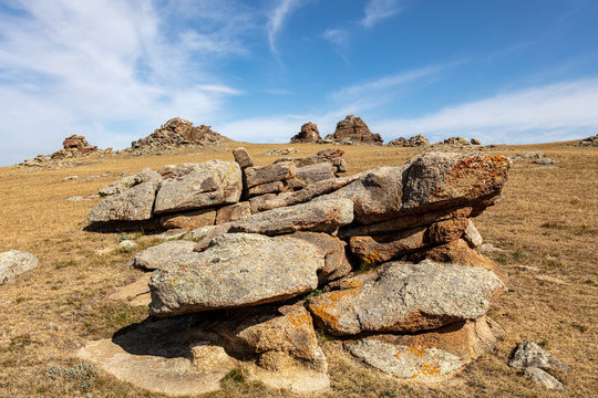 Rocks in the steppe of Mongolia.  A hill in the wilderness of central Mongolia near the town of Tsetserleg. Holy place in the nowhere of the desert. Ovoo, pile of stones use for praying 